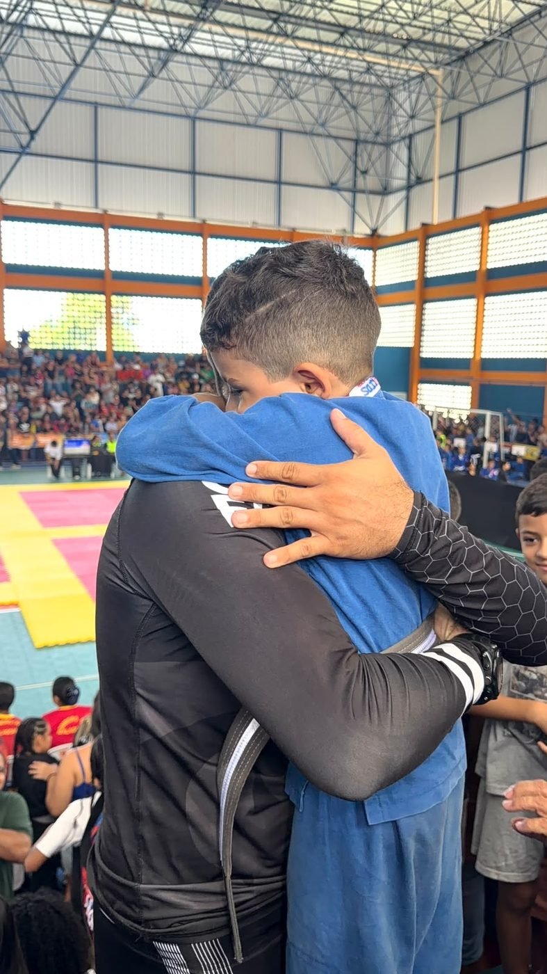 Professor Matheus Coimbra abraça um aluno depois da luta em campeonato de Jiu-Jitsu infantil